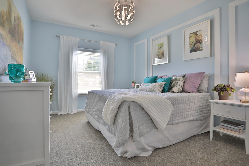 A bedroom with a large bed and a nightstand.