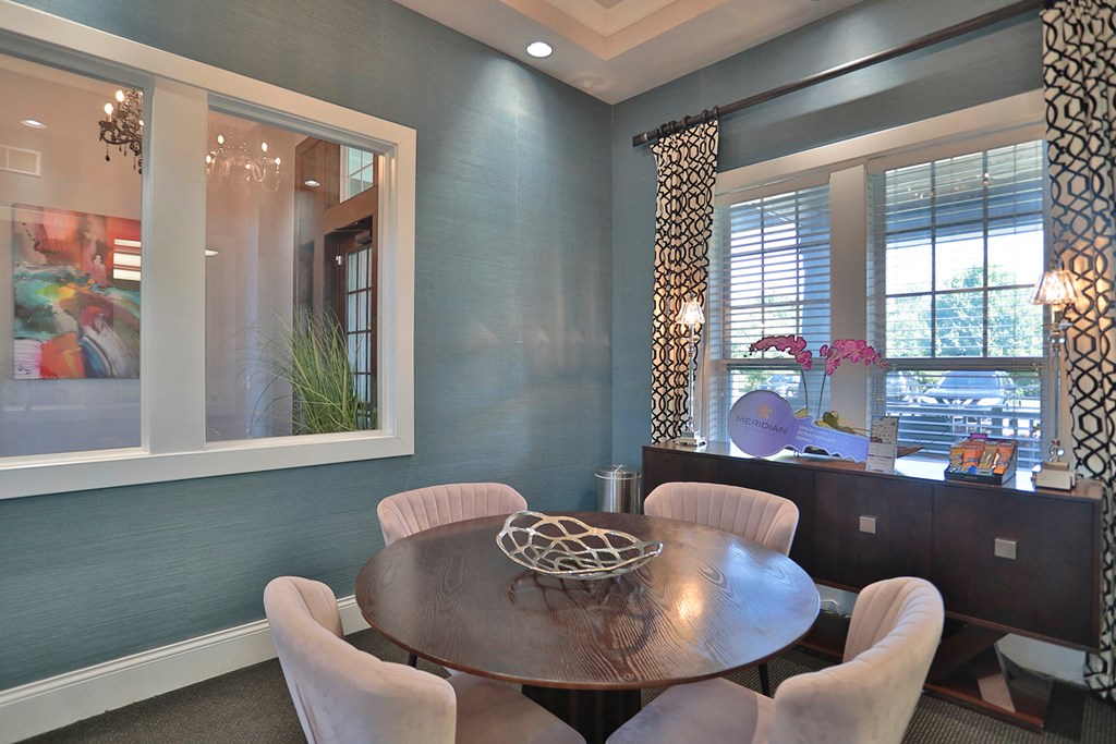 A dining room with a round table and chairs.