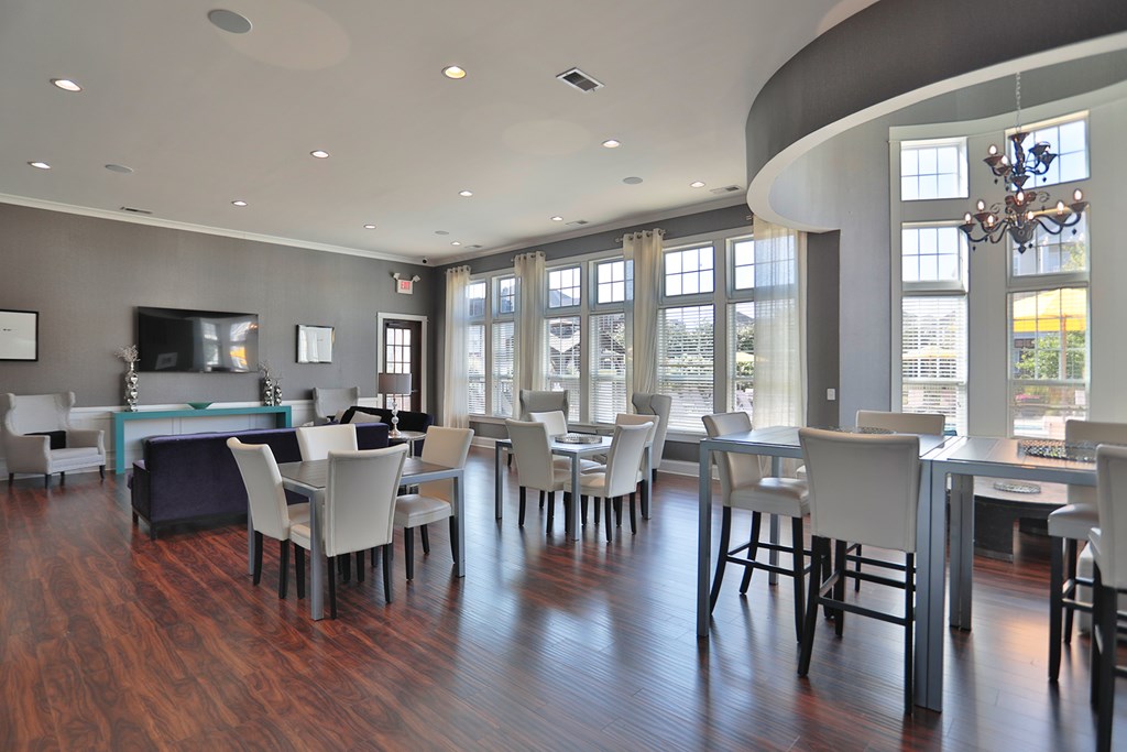 A modern dining room with a curved ceiling and wooden floors.