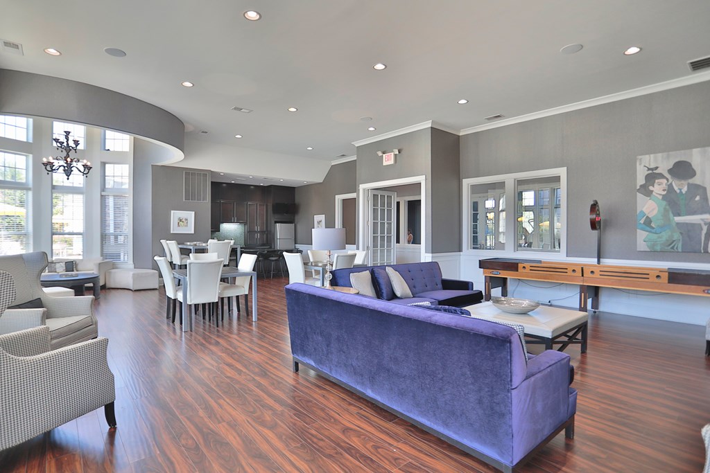A living room with a purple couch and a dining table.