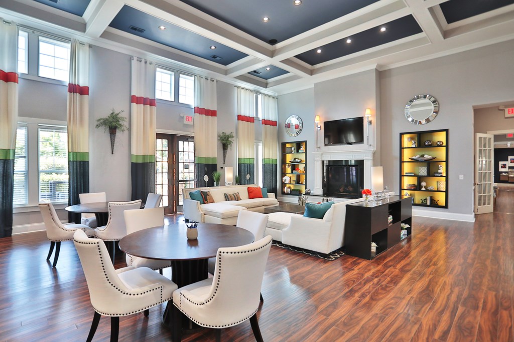 A large room with a wooden floor and a dining table with chairs.