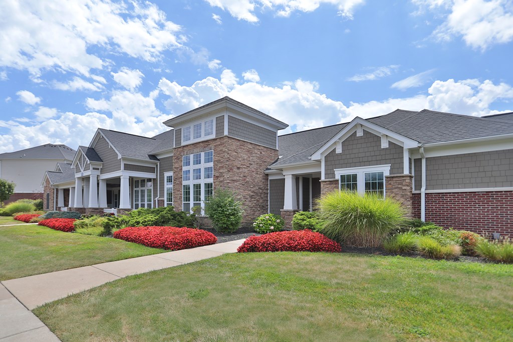 A large house with a grey roof and a brick wall.