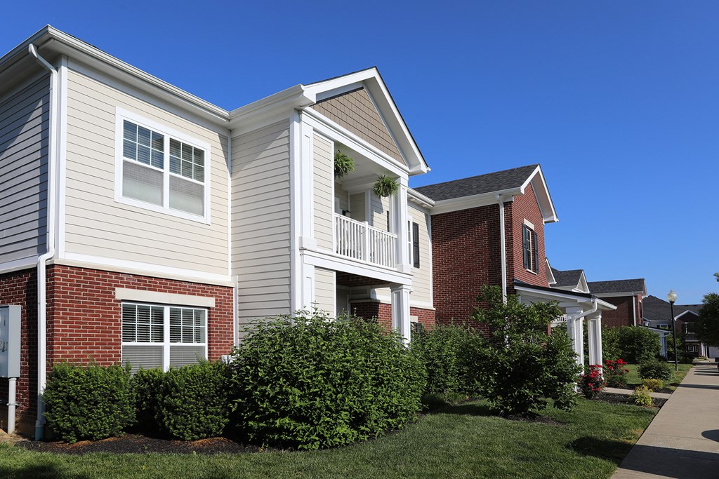 a row of town houses with bushes in front of them