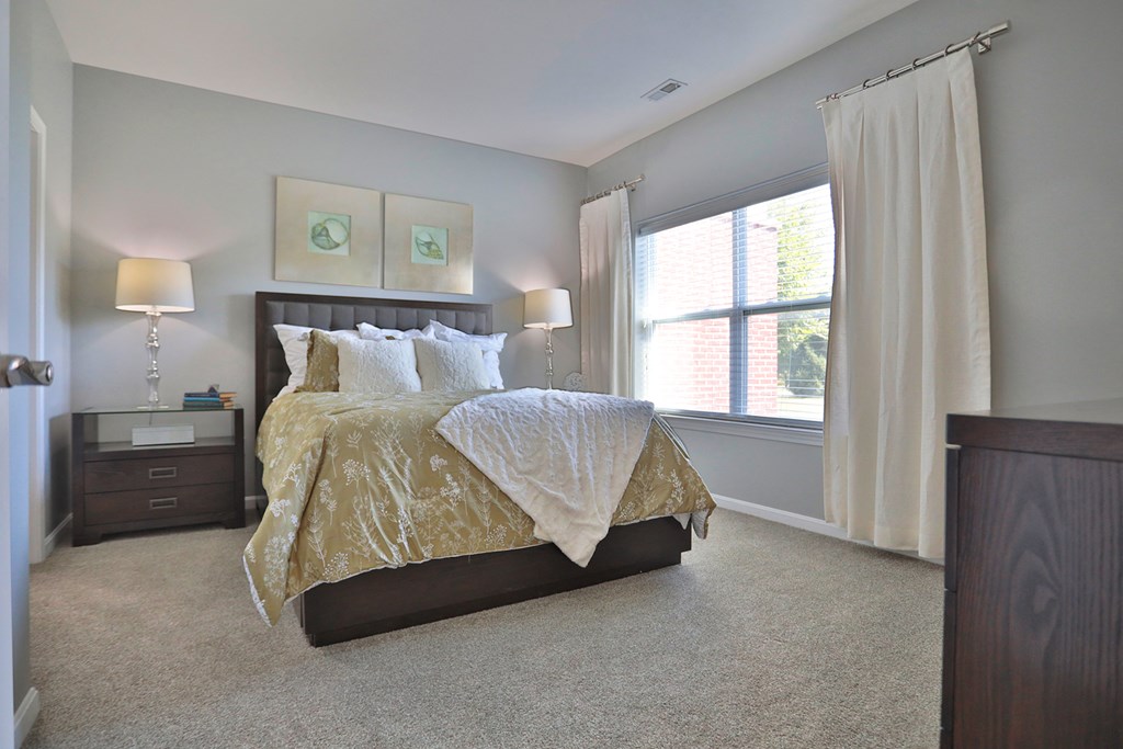 A bedroom with a large bed and a window.