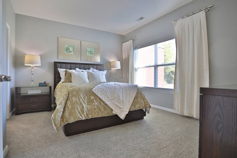 A bedroom with a large bed and a window.