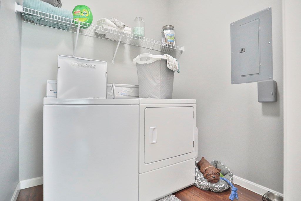 A white refrigerator with a white freezer and a white cabinet with a white towel hanging on it.
