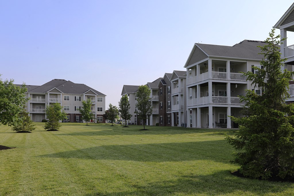an image of an apartment complex with a green lawn