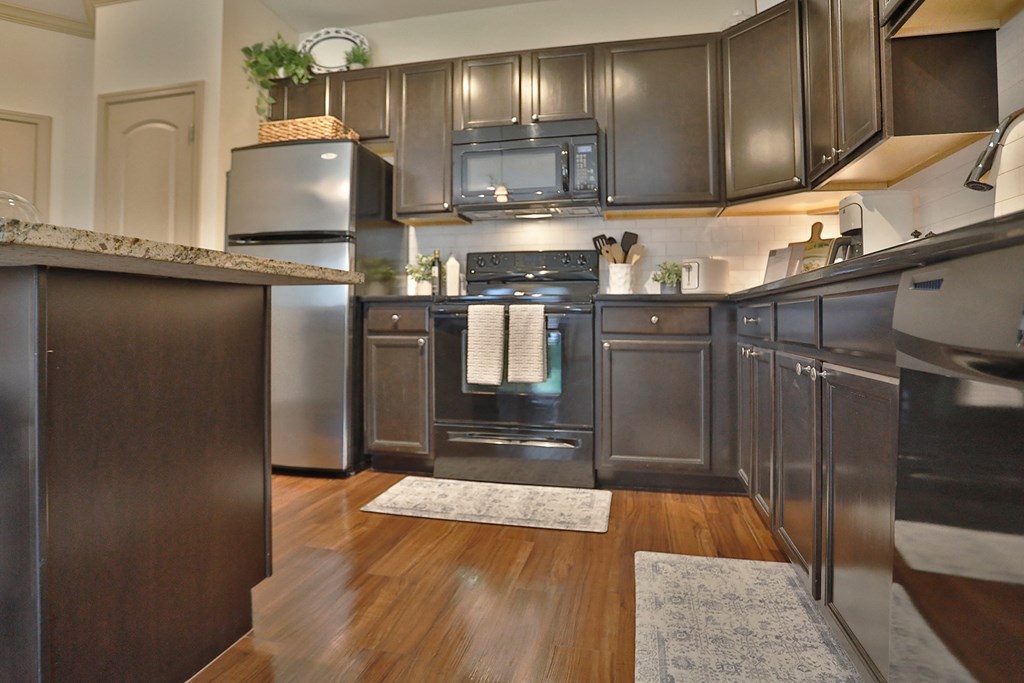 a kitchen with stainless steel appliances and dark wood cabinets