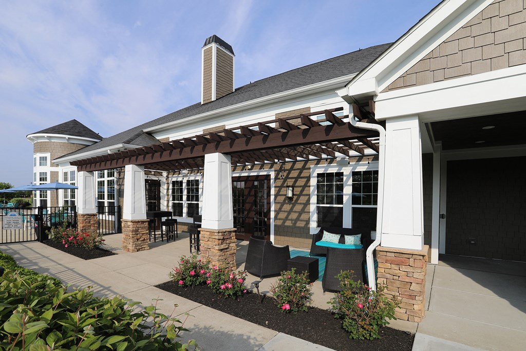 a patio with a pergola in front of a building