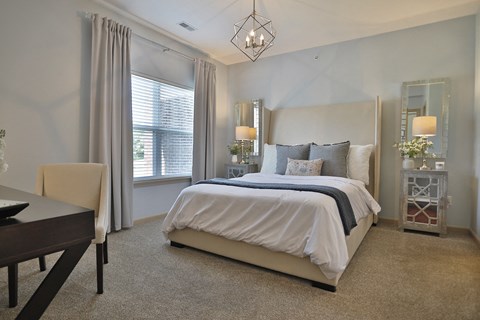 a bedroom with a bed and a table and chairs