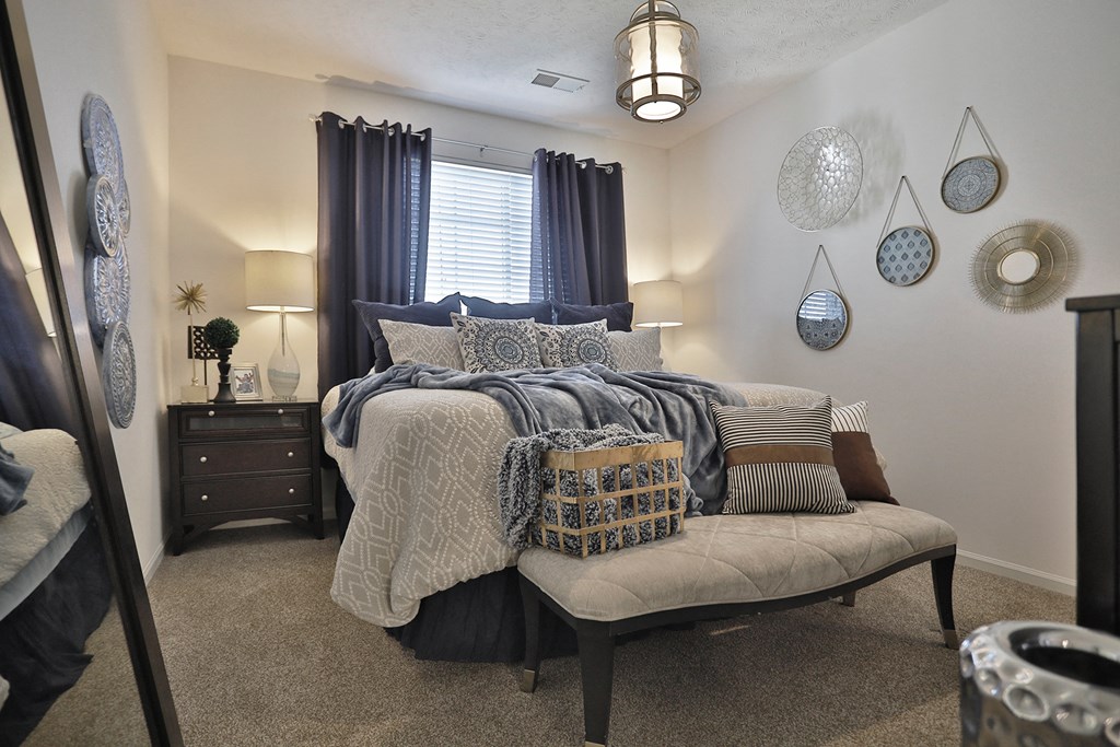 a bedroom with a bed with pillows and blankets on it