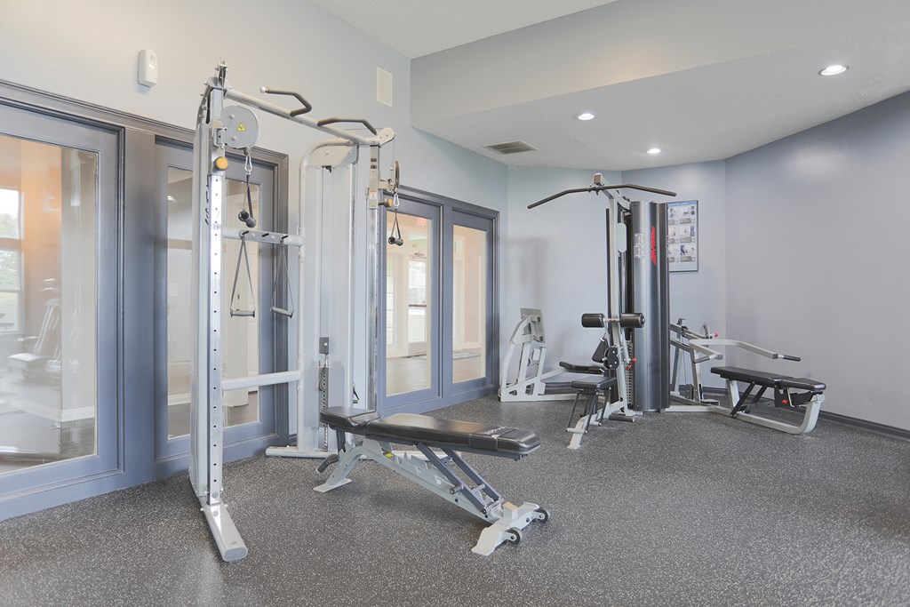 a gym with exercise equipment and mirrors in a building