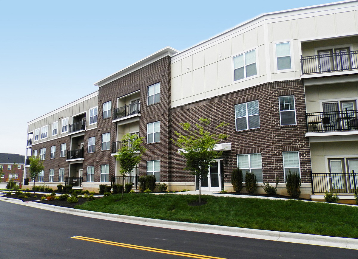 a brick and white apartment building on a street