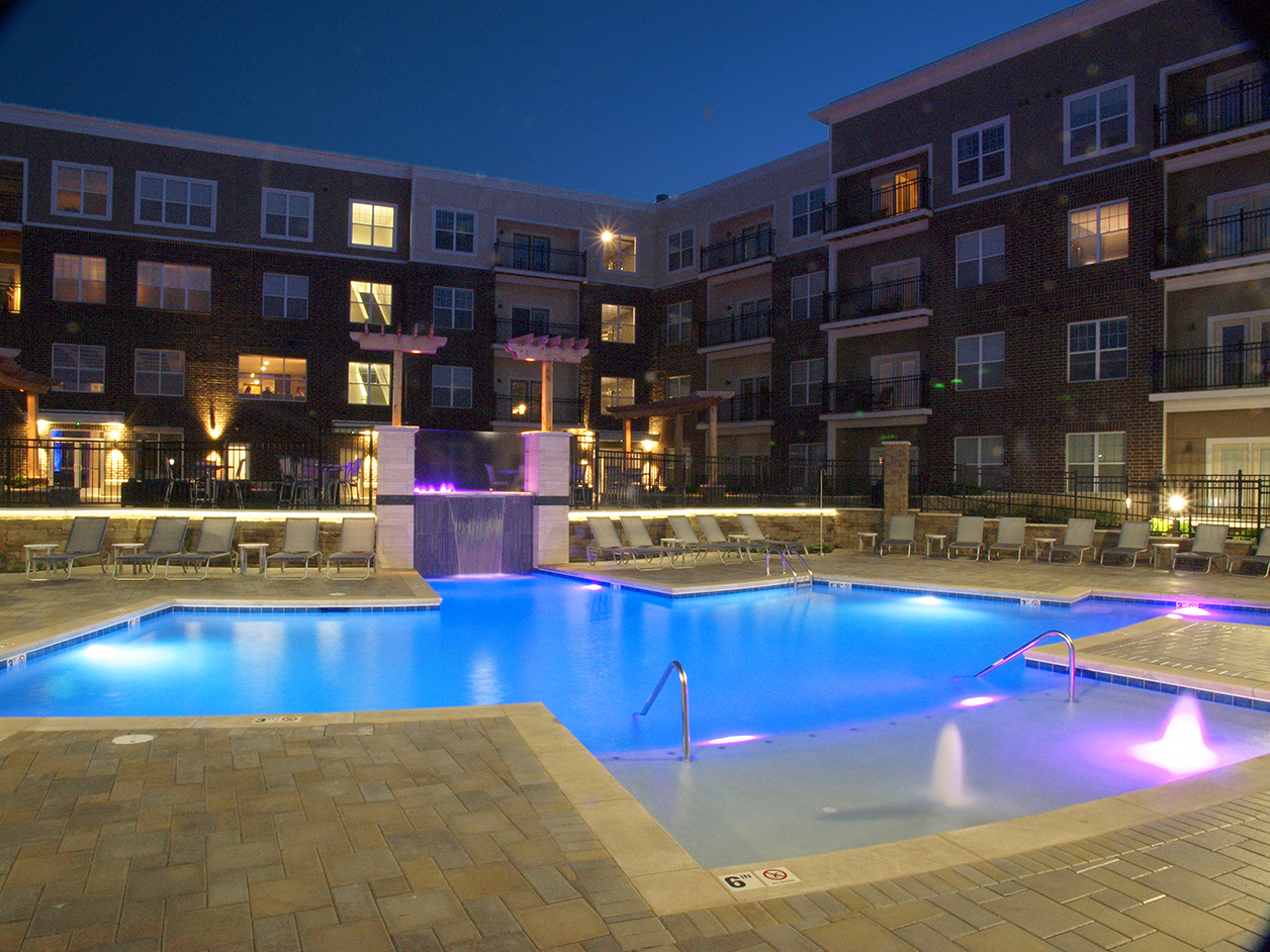 a swimming pool at night at an apartment complex