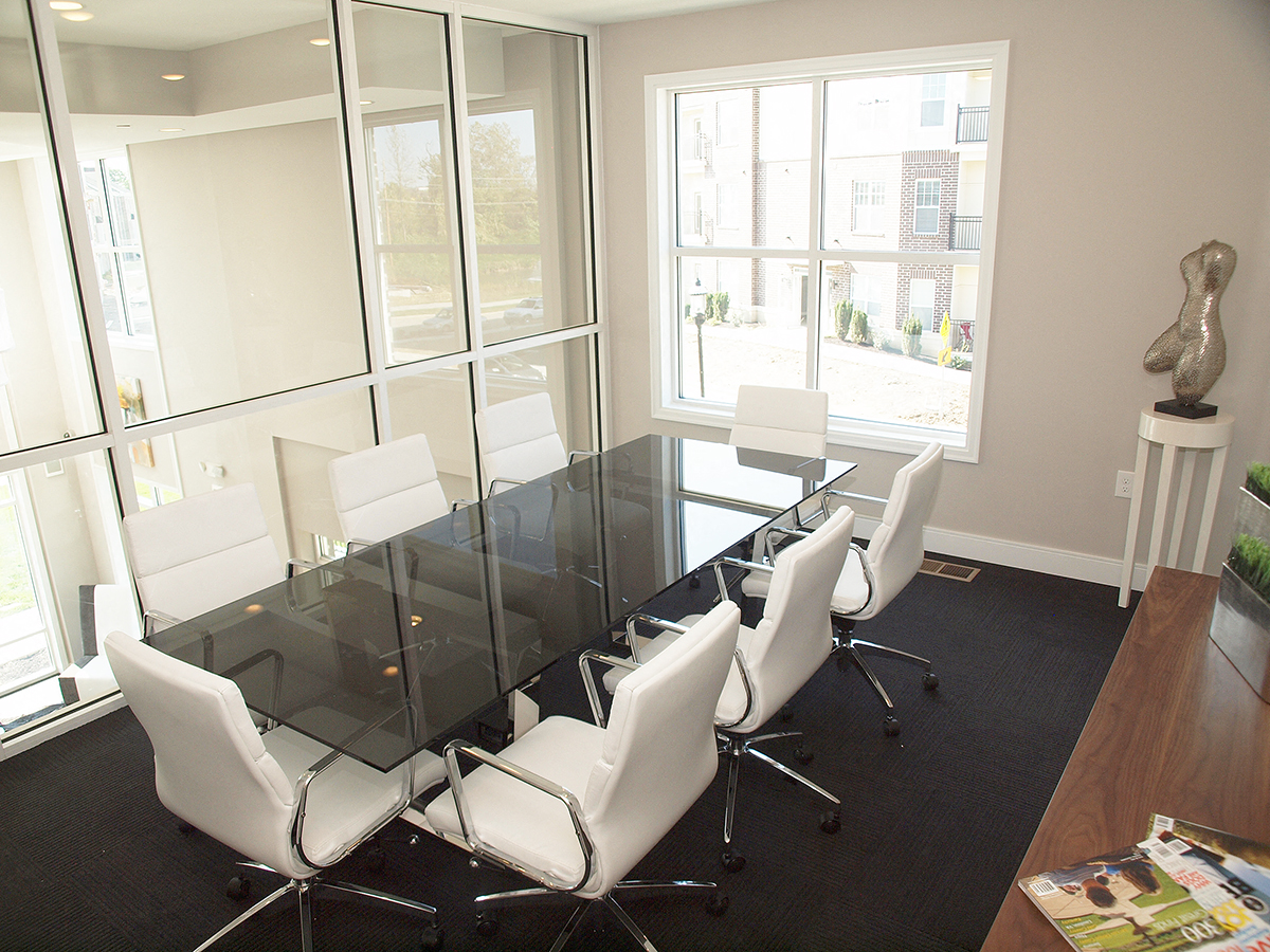 a conference room with a glass table and white chairs