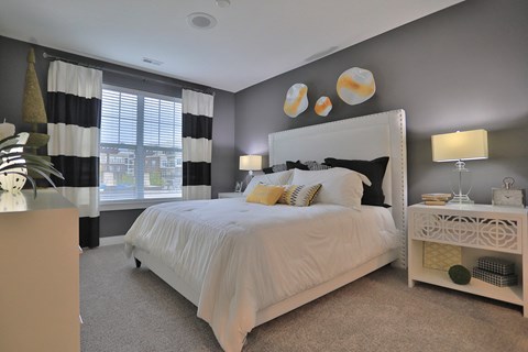 a bedroom with a white bed and black and white curtains