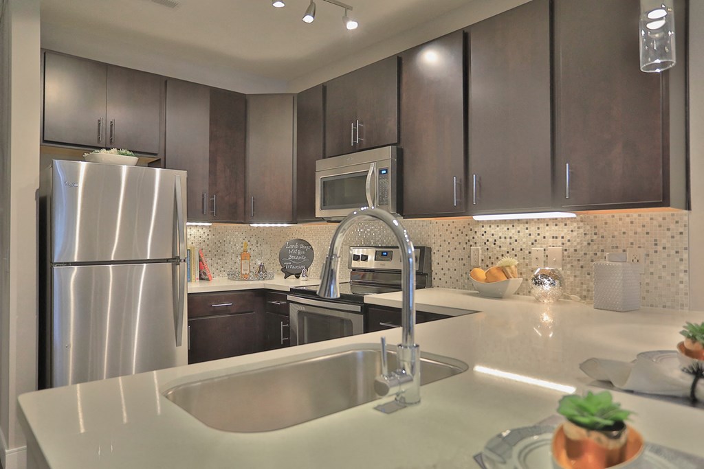 a kitchen with stainless steel appliances and white counter tops