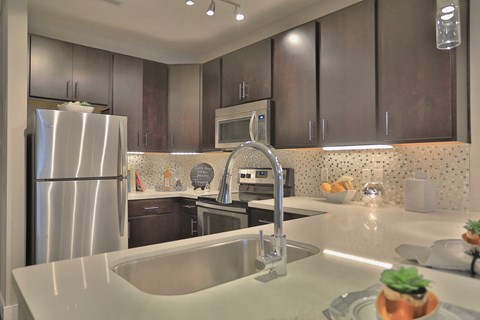 a kitchen with stainless steel appliances and white counter tops