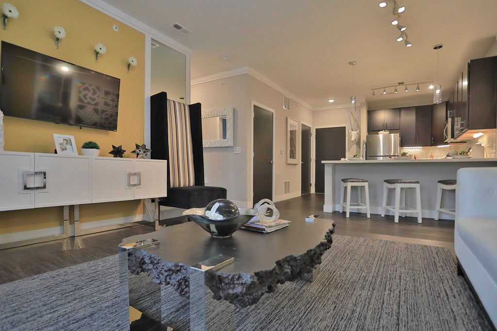 a living room with a table and a kitchen