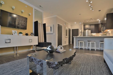 a living room with a table and a kitchen