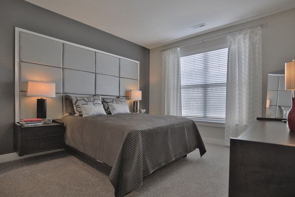 a bedroom with a bed and a dresser and a window