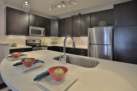 a kitchen with a large island and stainless steel appliances