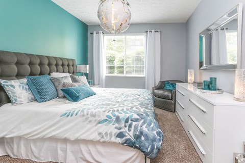 a bedroom with a bed and a dresser and a window