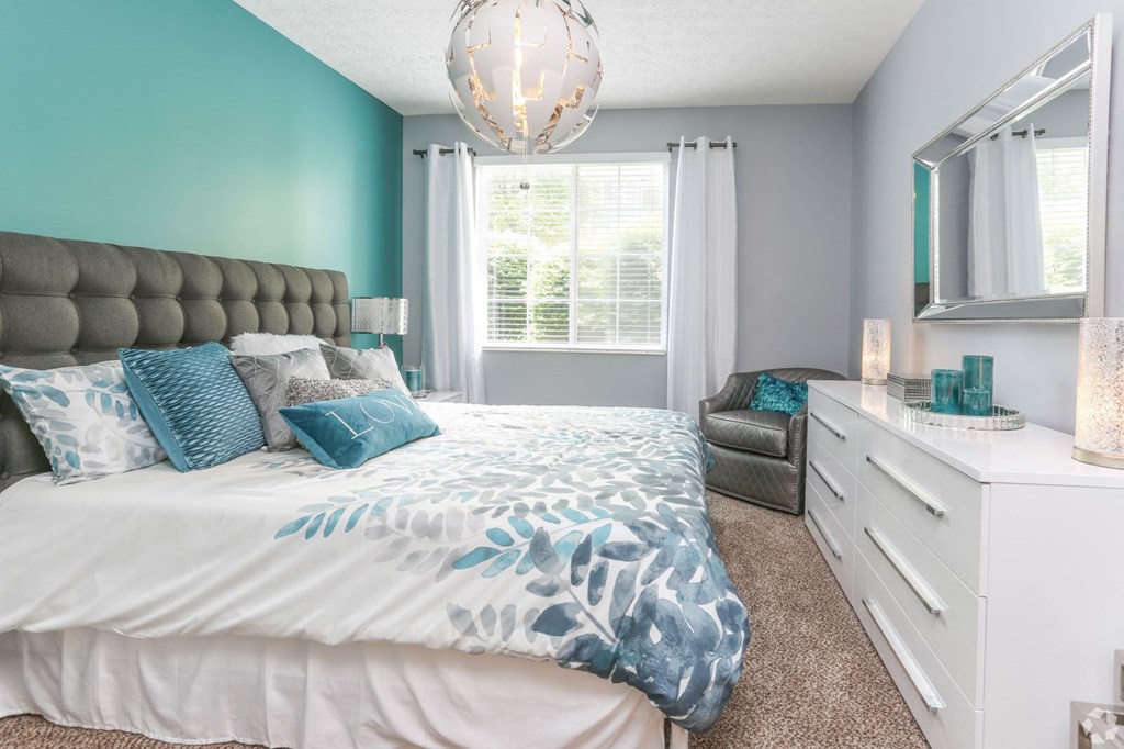 a bedroom with a bed and a dresser and a window