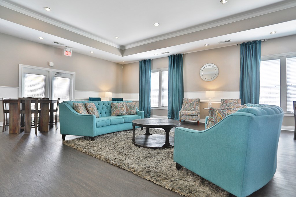 a living room with blue couches and chairs and a table