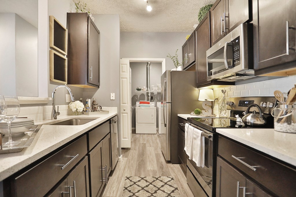 a kitchen with stainless steel appliances and white counter tops