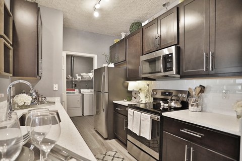 a kitchen with stainless steel appliances and white quartz counter tops