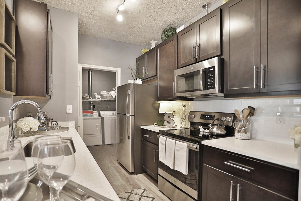 a kitchen with stainless steel appliances and white quartz counter tops