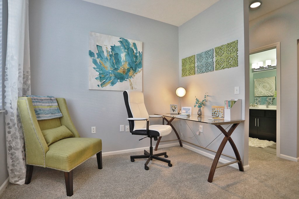a home office with a desk and chair and a mirror