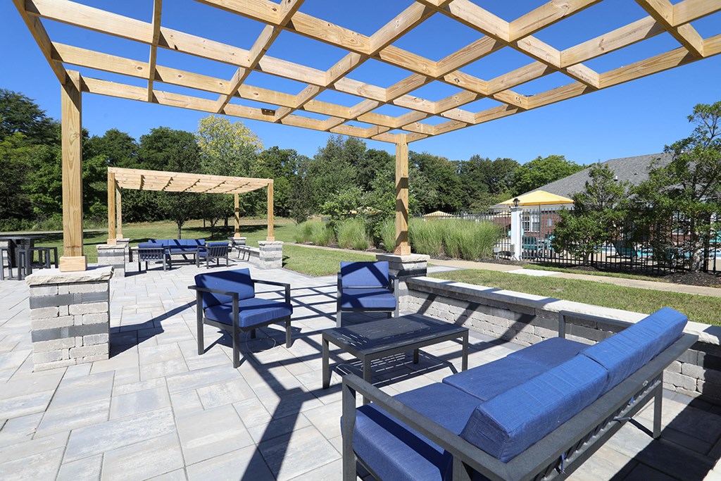 a patio with blue chairs and a pergola