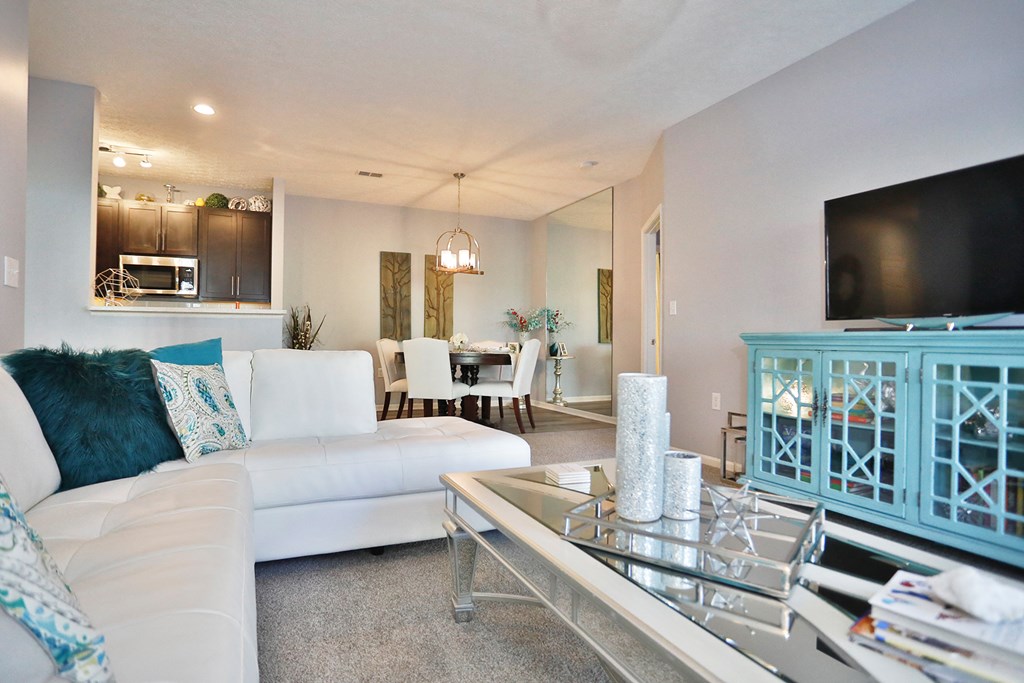 a living room with a white couch and a television