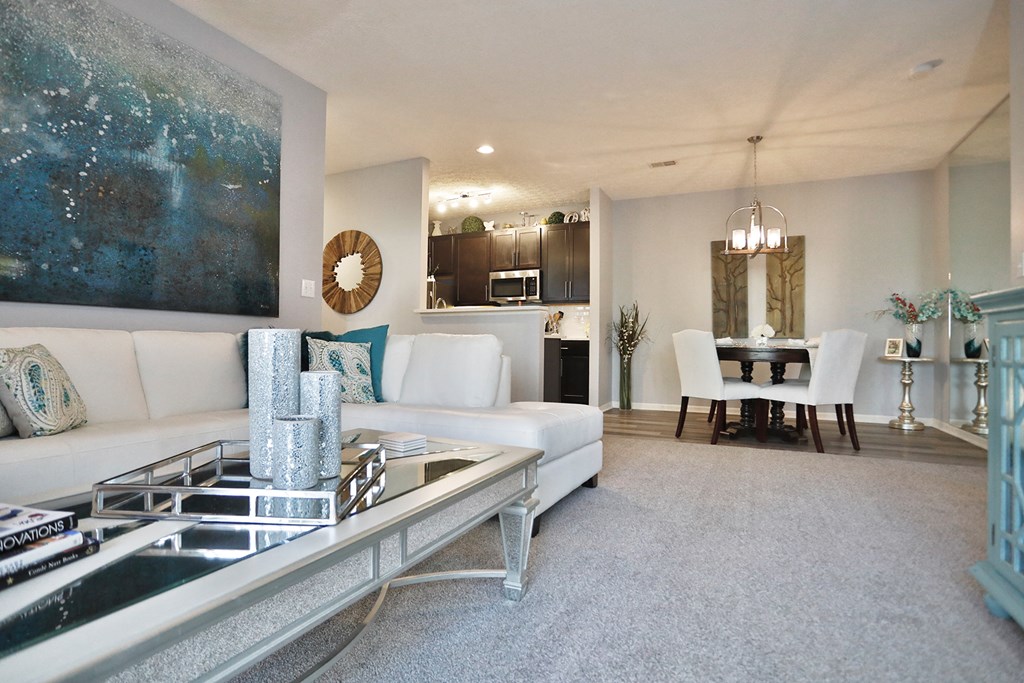 a living room with white couches and a glass coffee table