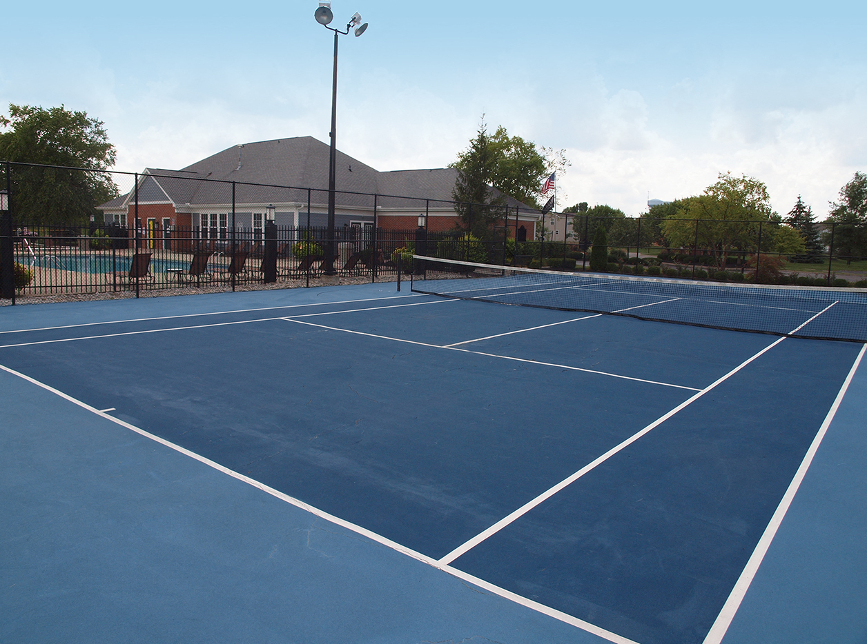 a blue tennis court with a building in the background