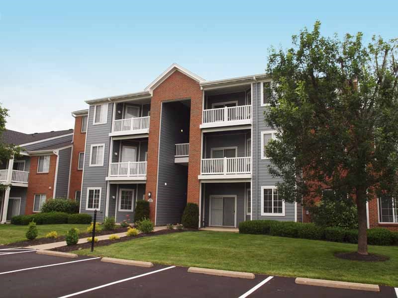 an apartment building with balconies and a lawn