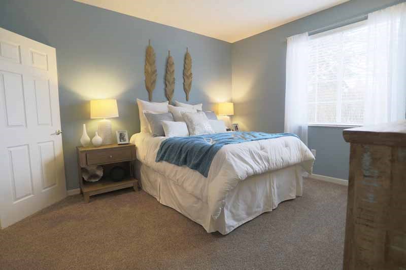 a bedroom with a bed and two windows