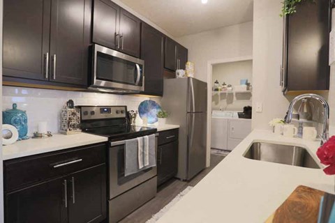 a kitchen with stainless steel appliances and black cabinets
