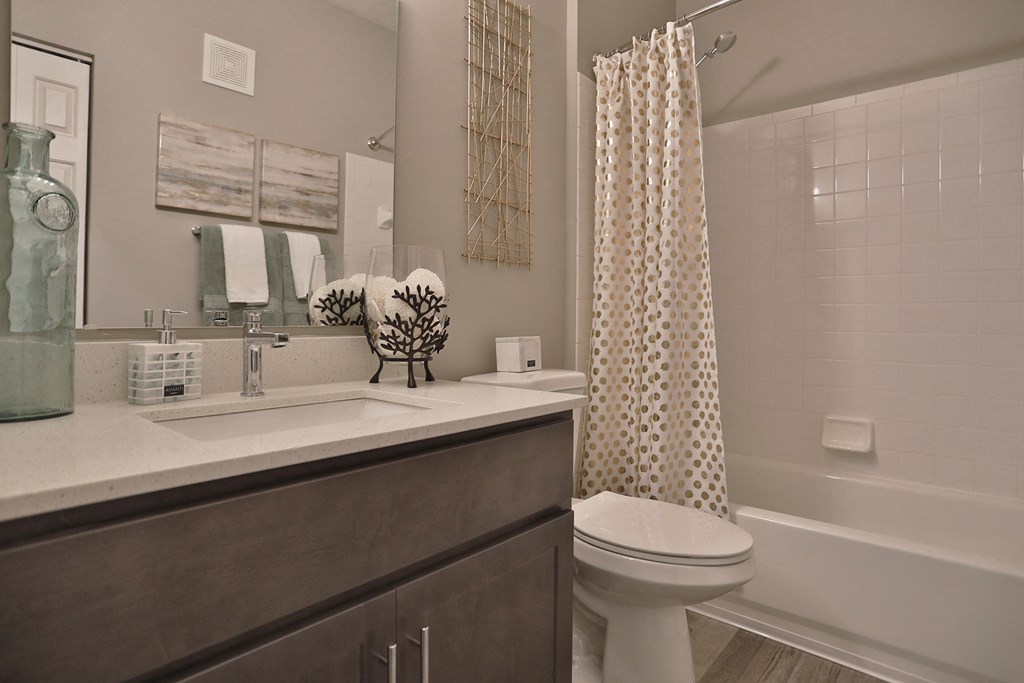 an open bathroom with a sink toilet and shower with a shower curtain