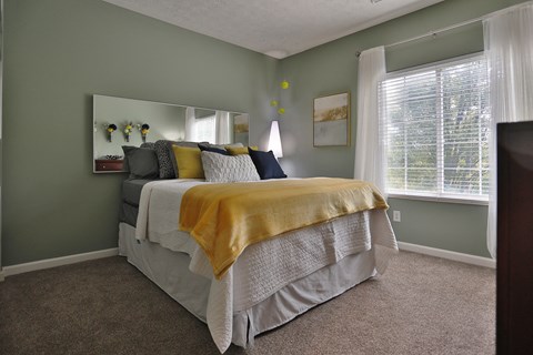 a bedroom with a bed and a large window