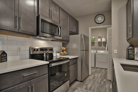 an open kitchen with stainless steel appliances and a refrigerator