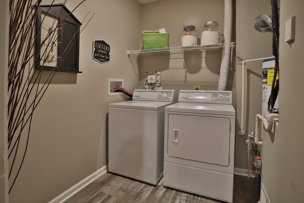 a laundry room with two washes and a dryer in it and a shelf