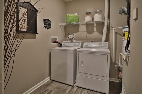 a laundry room with two washes and a dryer in it and a shelf