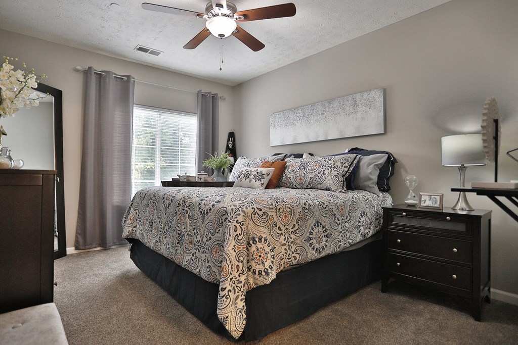 a bedroom with a bed and a ceiling fan