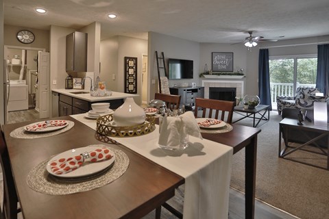 an open living room and dining room with a table with plates on it