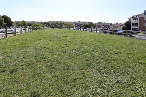 a large grassy field with a fence around it