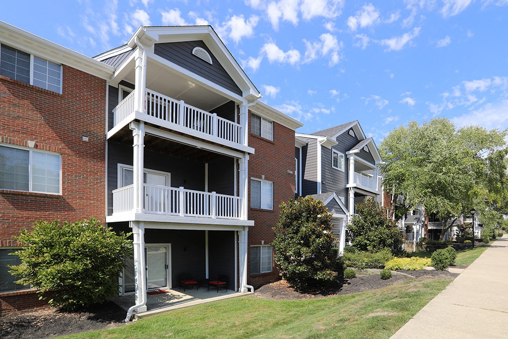 an apartment building with a balcony and a sidewalk