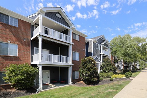 an apartment building with a balcony and a sidewalk